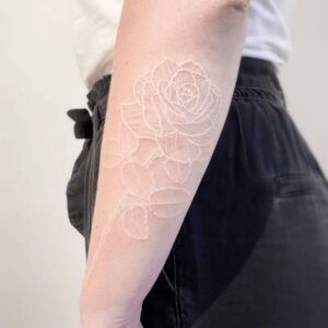 white ink tattoo design on forearm