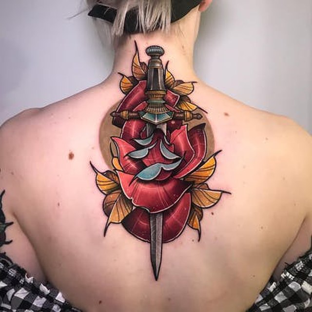 large upper back tattoo of dagger and rose