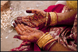 hands with henna tattoo designs and gold bracelets